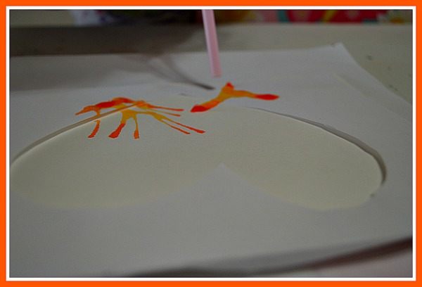 straw blown art with orange paint