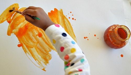 toddler enjoying pumpkin paints